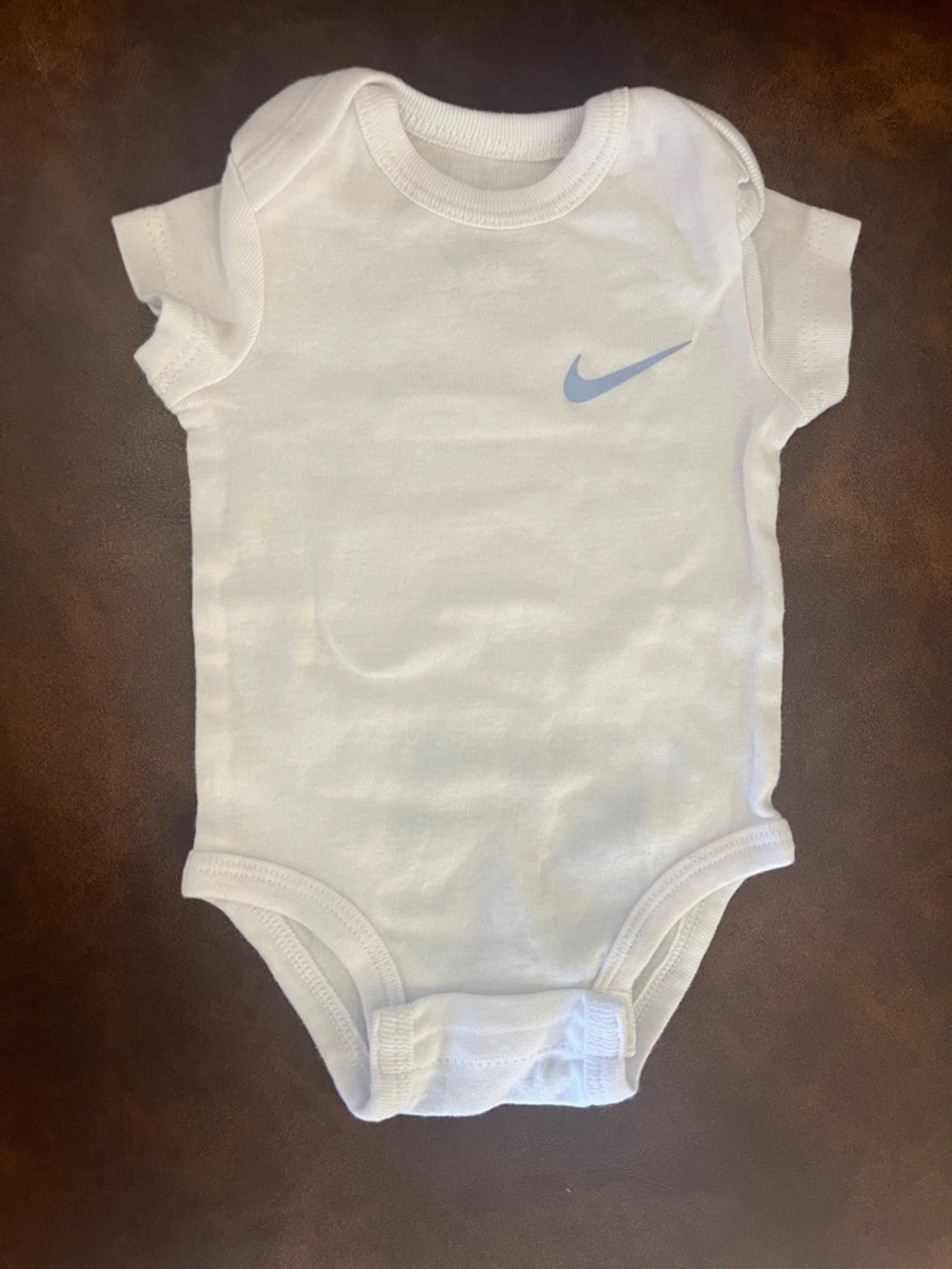 Nike White Infant Bodysuit with Light Blue Swoosh
